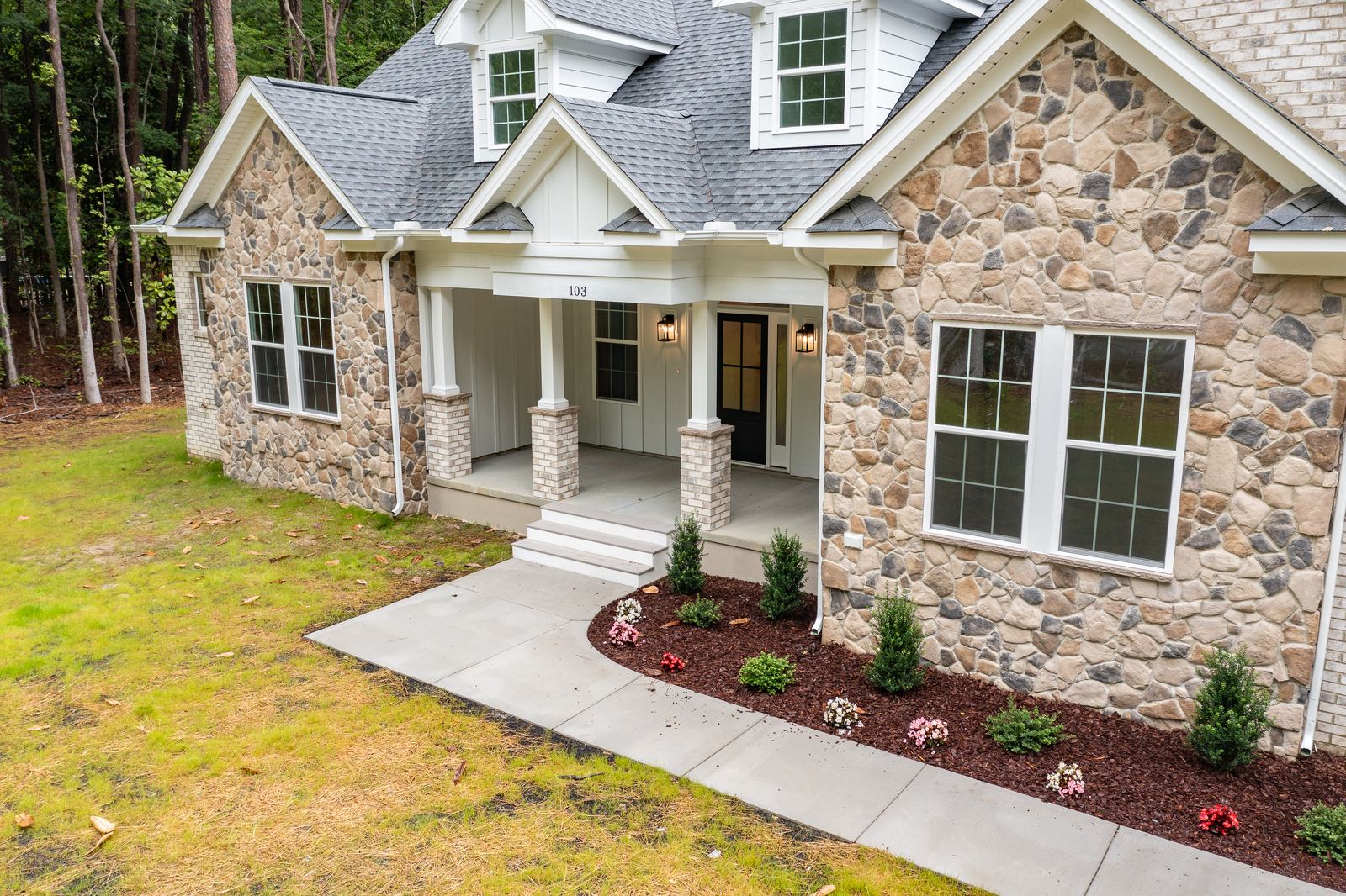 Front of a two-story Ava home with a stone facade
